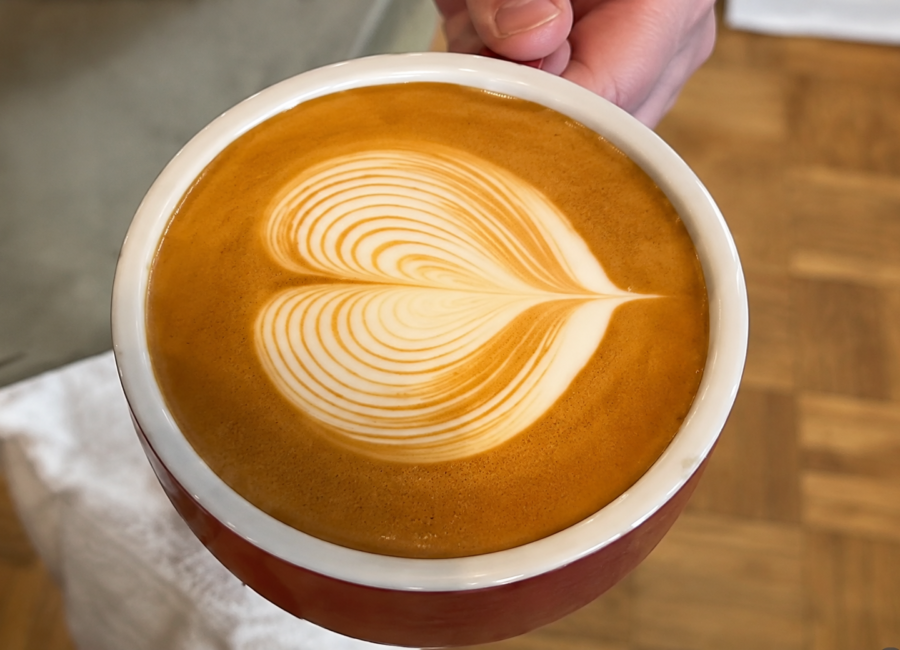 heart shaped latte art in a cup held in hand